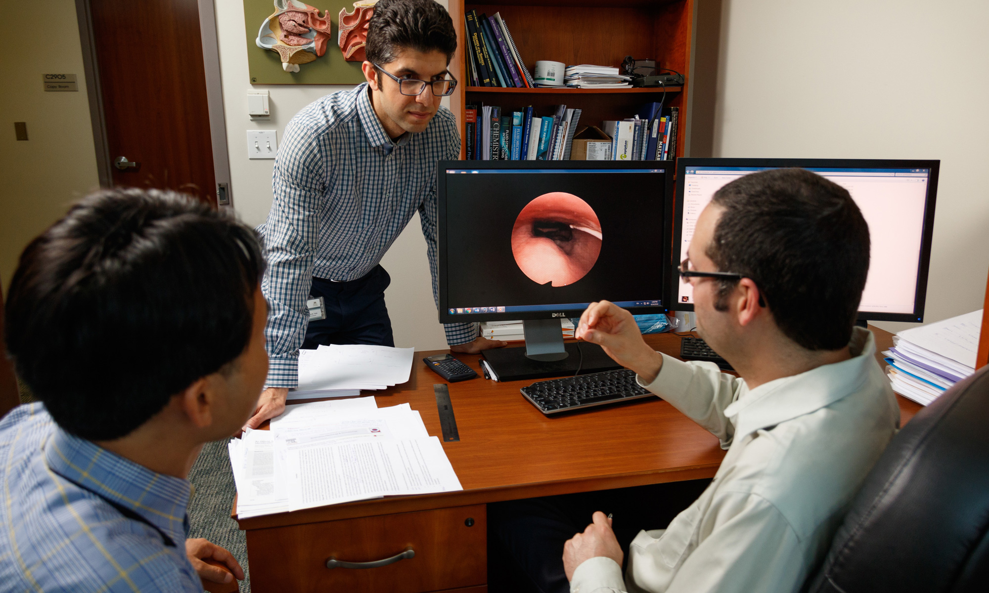 Dr. Guilherme Garcia discussing with students at computer in Airway Biomechanics Laboratory..