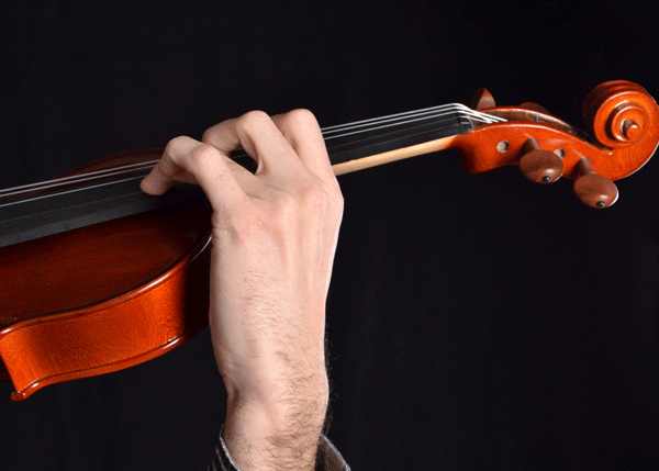 Hand holding base of violin