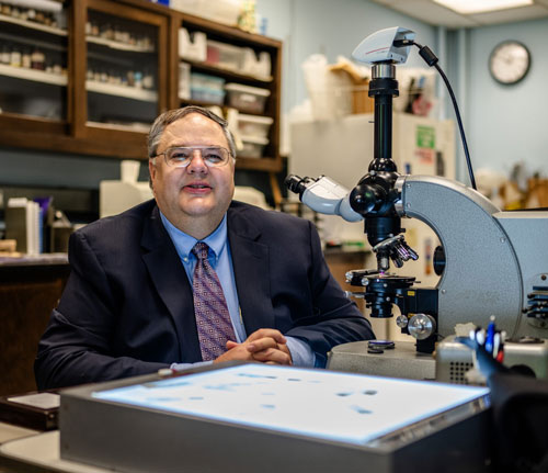 Dr. Jeffrey Toth with Microscope in OREC's biomaterials lab