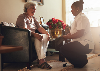 Healthcare worker speaking with elderly lady in residence
