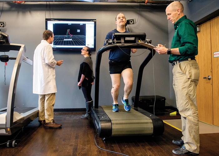 Physicians working with patients in room with treadmills